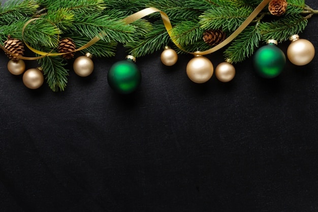 Christmas deco with fir and baubles on dark background. flat lay. christmas concept Premium Photo
