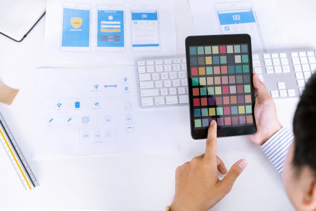 Creative startup ux ui designers team choosing color samples for designing mobile application screens layout. Premium Photo