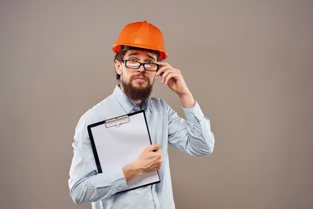 Man in a working uniform with orange hard hat isolated Premium Photo