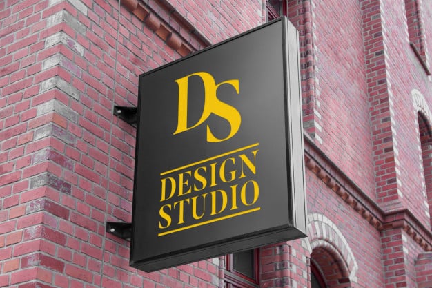 Mockup of modern vertical black hanging logo sign on red brick wall classic building facade Premium Psd