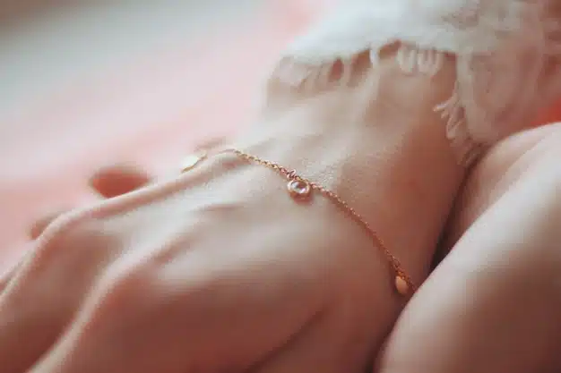 Closeup shot of a female wearing a fashionable bracelet with charm pendants Free Photo