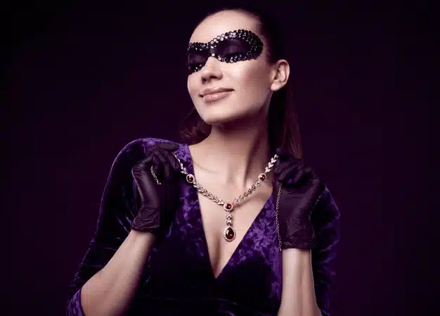 Elegant brunette woman in beautiful purple dress, sequins mask and black gloves Free Photo
