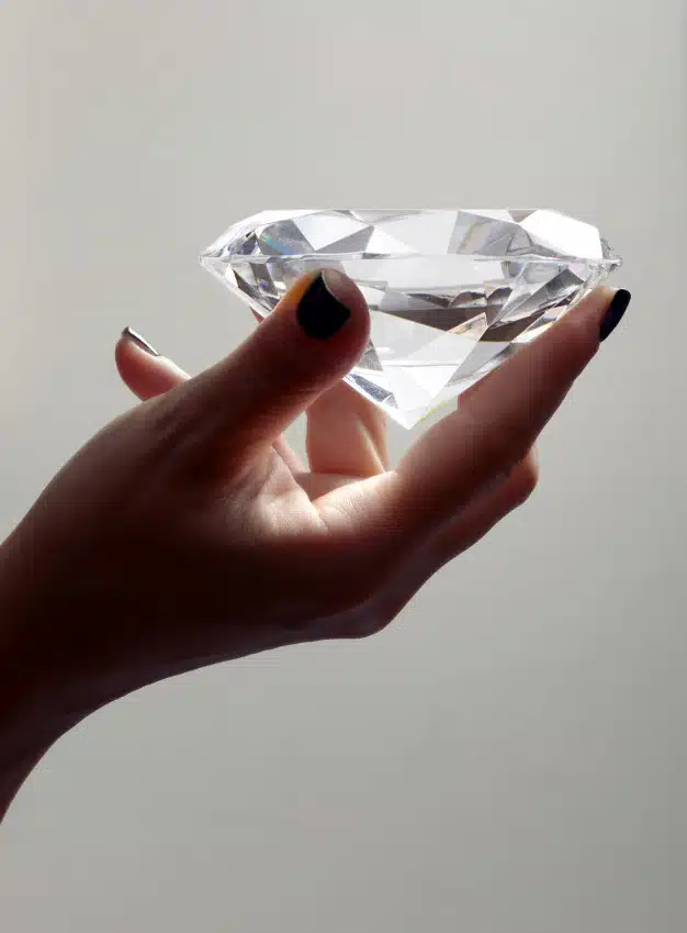 Female hand holding oversized diamond Premium Photo