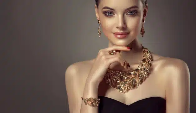 Portrait of young gorgeous woman dressed in a jewelry set of necklace,