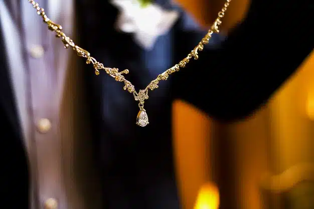 The groom in a suit gives the bride a necklace with diamonds for the wedding or valentine's day Premium Photo