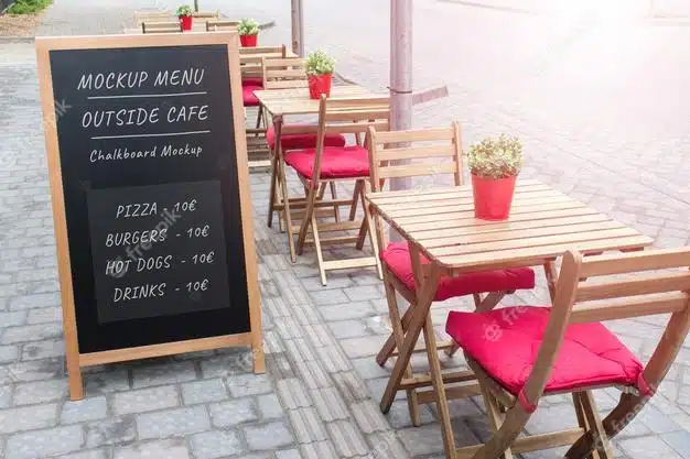 Editable psd mockup template of summer outside cafe black menu board with wooden tables and chairs. Premium Psd